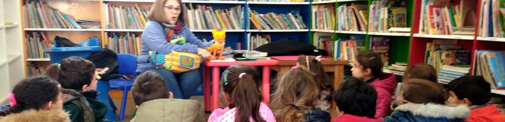 Narradora con grupo de niños en biblioteca